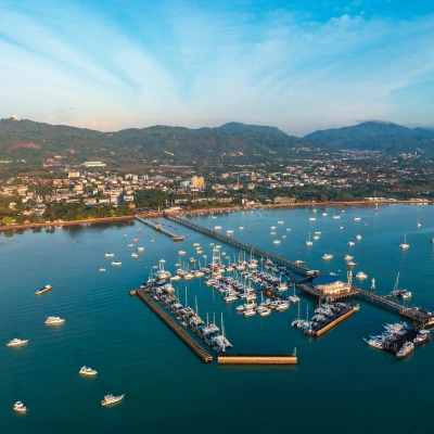 Aerial view of Phuket's Patong Beach with sunbathers and umbrellas.